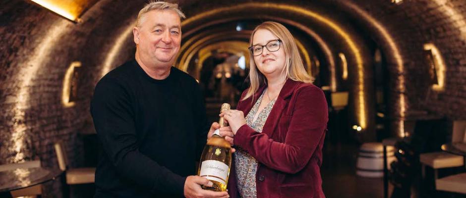 Aurore Jeudy übergibt Andreas Vitasek eine Flasche Schlumberger zum Einstand als Sekt-Botschafter